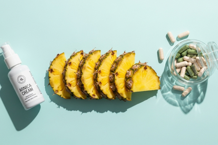Fresh pineapple slices a bottle of arnica cream, and supplement.